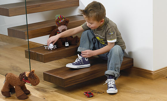 [Translate to EN:] Osmo - Anstrich, Farbe, Pflege und Schutz für Treppen - Kind spielt auf der Treppe  OSMO